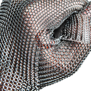 butcher in mesh metal glove holds a sharp knife